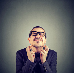 Hopeful man crossing fingers for luck