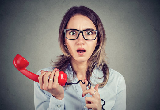 Shocked business woman receiving bad news over the telephone