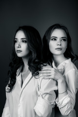 Two beautiful girls posing in white shirt and jeans