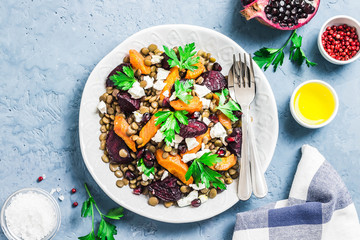 Healthy vegetarian salad, roasted root vegetables, lentils and feta cheese.Top view, space for text.