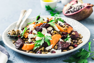 Healthy vegetarian salad, roasted root vegetables, lentils and feta cheese. Selective focus, space...