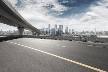 asphalt road with city skyline