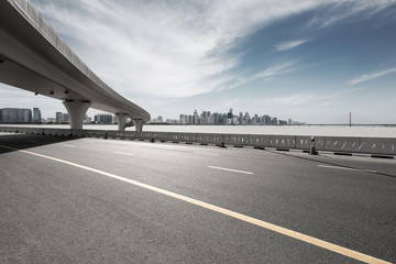 asphalt road with city skyline