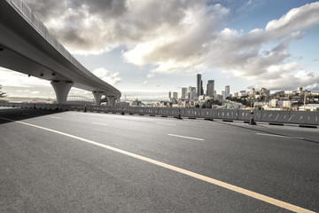 asphalt road with city skyline