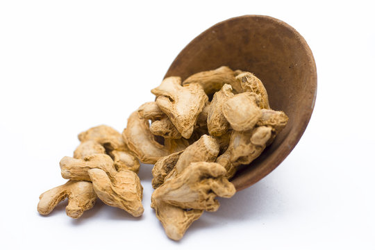 Close up of Dried ginger or Sonth isolated on white in a clay bowl.