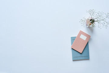 flowers and notebooks on white table bright atmosphere