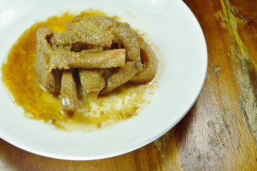 roasted pork slice in white plate on wooden table