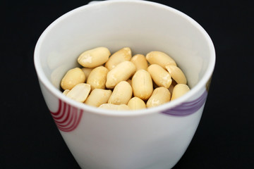 Detail of delicious peanuts in white cup