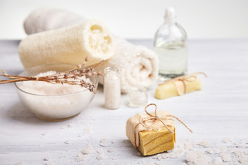 Fototapeta na wymiar Bar of homemade soap, dry lavender flowers and essential oil. Selective focus. Natural cosmetic oil, sea salt and handmade soap on light background. Aromatherapy, spa and wellness concept