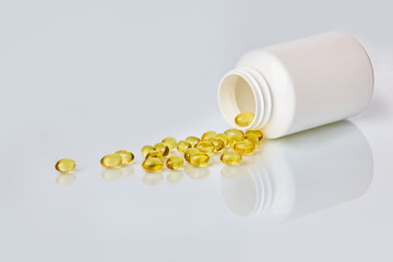 Fish oil capsules on white background.  Healthcare concept.  Scattered supplements.  Space for text.  Horizontal