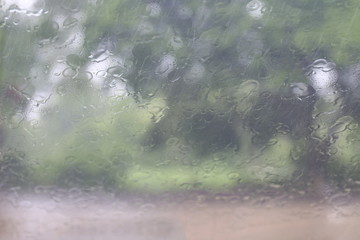 Rainy season, Splash Rain droplets Natural Water Drops on Glass Window in Rainy Season tree background, Rain mist drizzle, Rain drizzling
