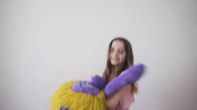 Girl jumping while hugging a stuffed animal