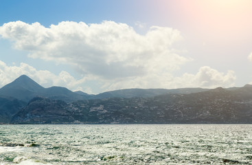 Summer landscape with sun, sea and mountain range