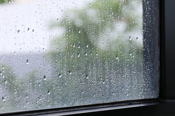 Water of Raindrops fresh on surface window glass in rainy season (Selective focus)