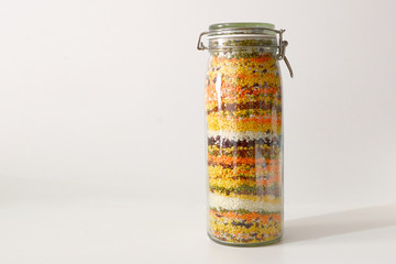 glass jar with colored croup and cereals