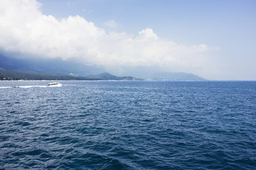 Blue calm Mediterranean Sea, mountains and white yacht