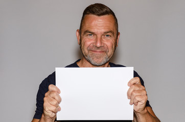 Attractive smiling middle-aged man holding a sign