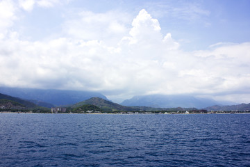 Calm Mediterranean Sea and mountains with green trees in Antalya