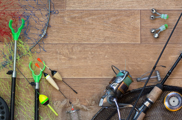 Fishing tackle - fishing spinning, hooks and lures on darken wooden background.Top view.