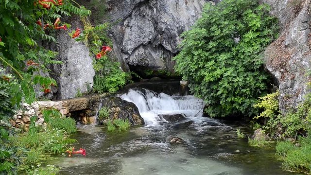 River source. Karst spring with clean and fresh water. Cascading river in nature. Water source and cave