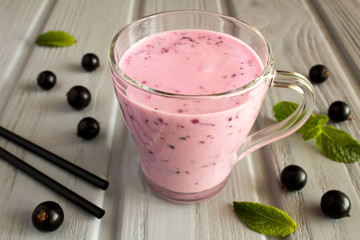 Yogurt smoothies  with  black currant  on the grey  wooden background