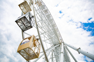 Ferris wheel on cloudy sky background