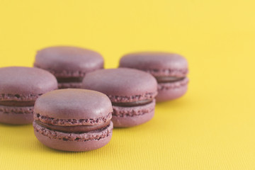 Obraz na płótnie Canvas Purple French Macarons on a Yellow Background