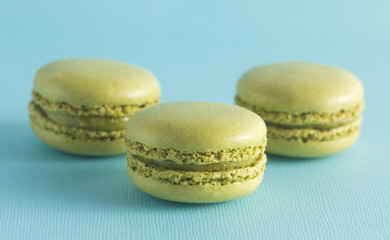 Green French Macarons on a Blue Background