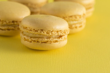 Fototapeta na wymiar Yellow French Macarons on a Yellow Background