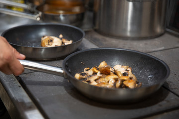 chef cooking stir fry mushroom sliced in pan at a restaurant, stir fry vegetables in the wok