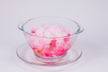 A glass of sweet ice with milk and red syrup with white background