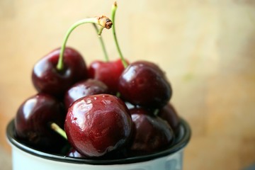 fresh, sweet cherry in a mug. on a wooden background