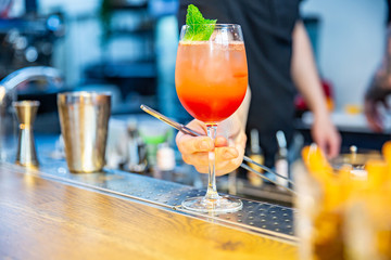 Bartender finished decorating his cocktail with mint