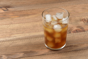 Vaso de café con hielo sobre mesa de madera