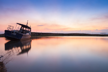 Obraz premium Reflection of boat on water at sunset time