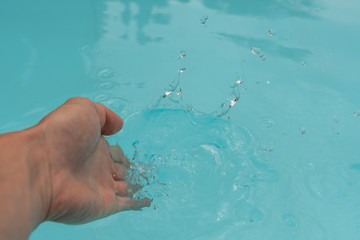 Mit der Hand im Wasser spritzen