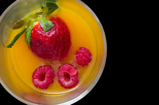 high view of non-alcoholic cocktail with strawberry and raspberry juice with black background