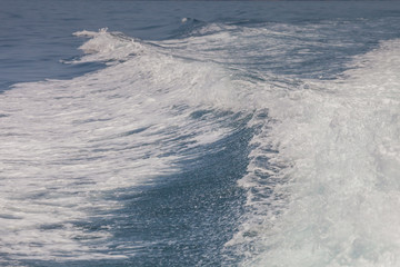 Blue color of ocean is splashing on waves from speed boat