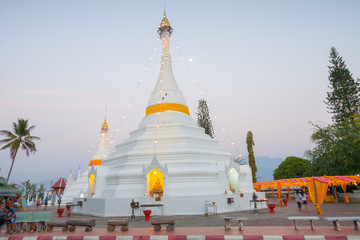 A white color of pagoda decorated by lighting at night time under clear sky located at north of Thailand