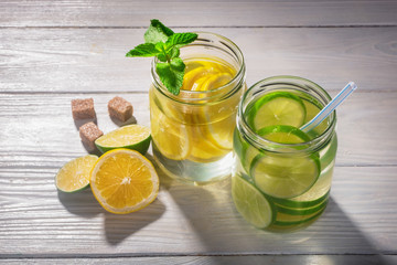 Composition with summer lemonade with lemon, lime and mint on wooden table. View with copy space