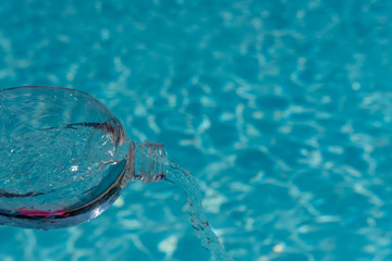 Wasser aus Plastiklasche schütten auf blauem hintergrund 