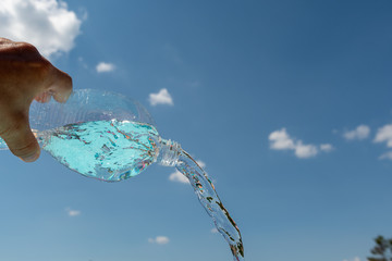 Wasser aus Plastik Flasche schütten