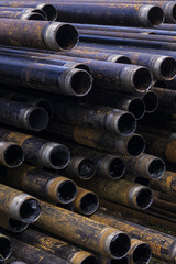 Oil Drill pipe. Rusty drill pipes were drilled in the well section. Downhole drilling rig. Laying the pipe on the deck. View of the shell of drill pipes laid in courtyard of the oil and gas warehouse.