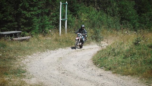 enduro motorcyclist on an off-road dirt bike motorcycle rides on a road among the beautiful mountains, travel concept, slow motions