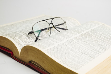 Glasses on open book with white background