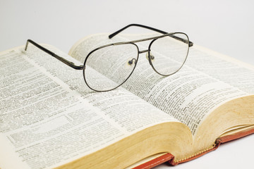 Glasses on open book with white background