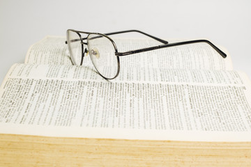 Glasses on open book with white background