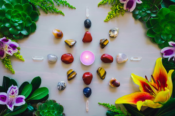 Crystal Grid with Candle Center on Grey Table with Summer Botanicals