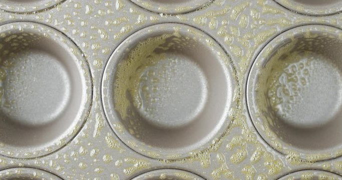 Close Video Of Spraying A Muffin Pan With Non Stick Cooking Spray.