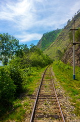 Summer landscape with Circum-Baikal railway on shore lake Baikal. Blurred foreground from train movement